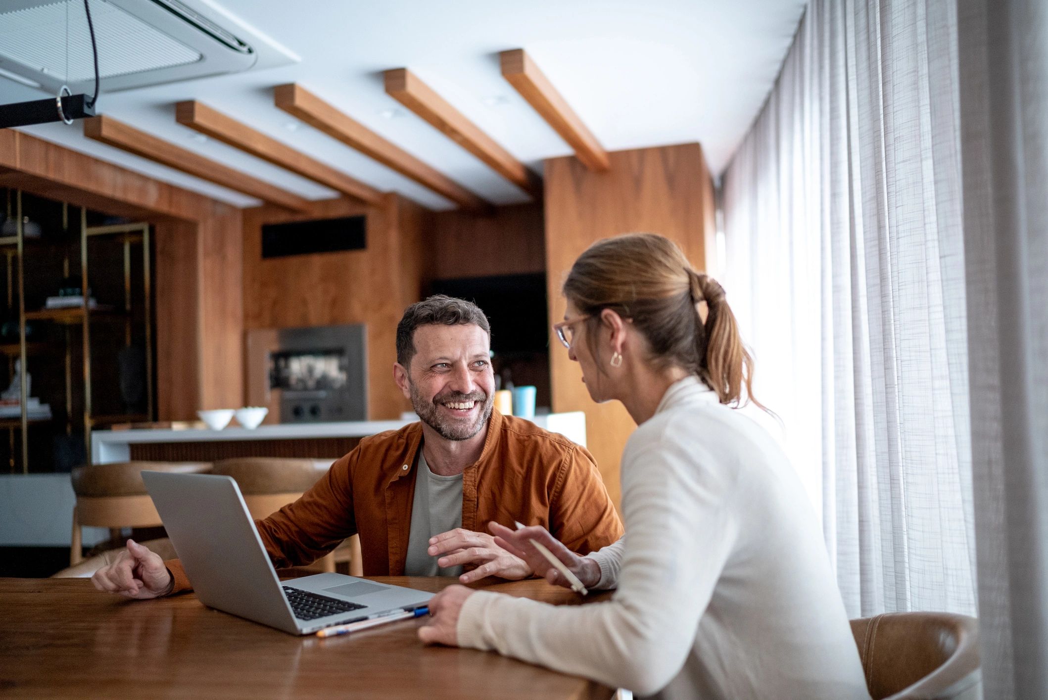 Technician assisting a customer with a laptop at home